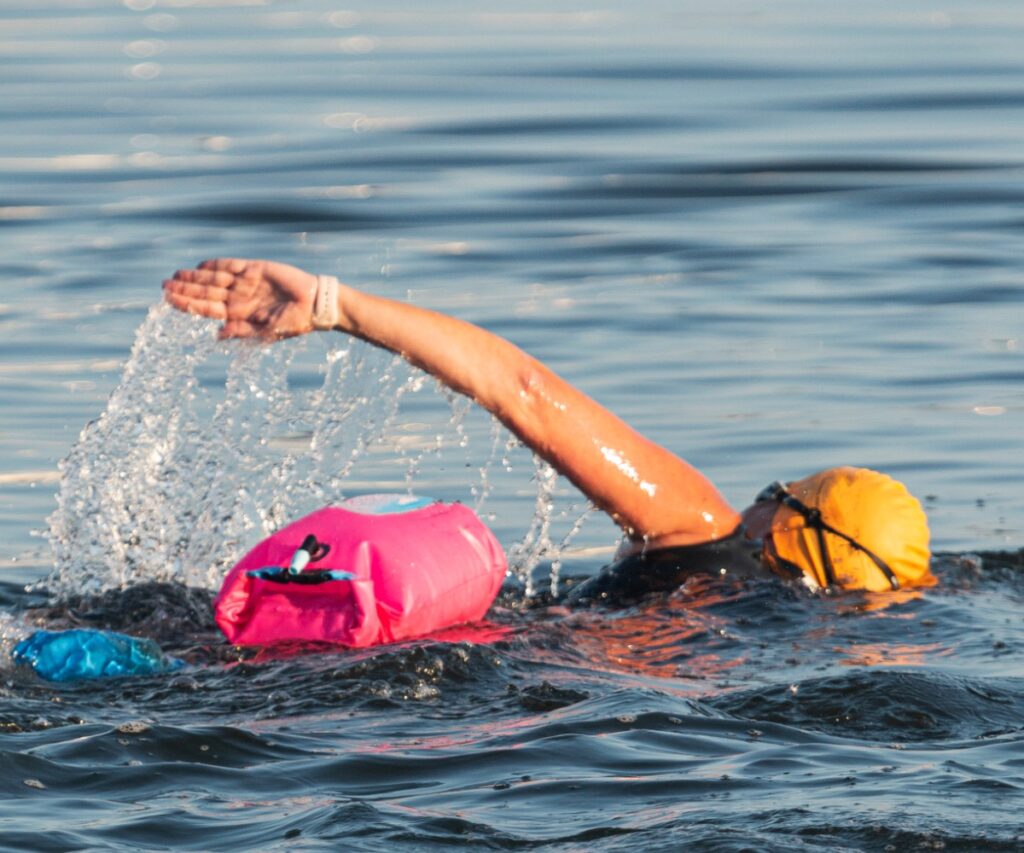 Ein Schwimmer im Freiwasser zieht eine Schwimmboje hinter sich her