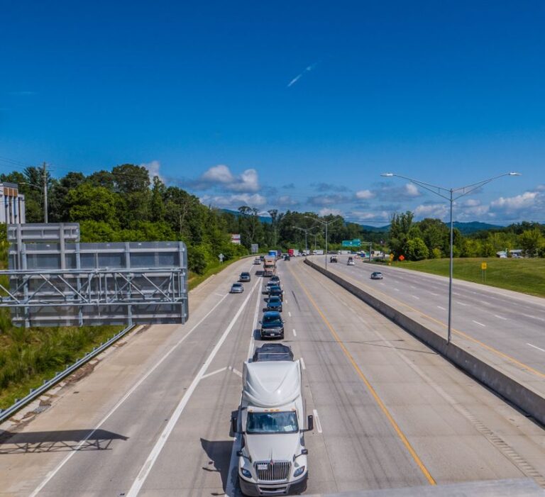 Sonnige Autobahn mit dichtem Verkehr bei blauem Himmel